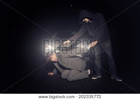 Assassin shooting man in suit with silented handgun