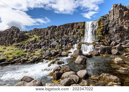 Beautiful Oxararfoss waterfall in summer Thingvellir National Park Iceland selective focus