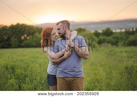 A Young couple enjoying the sunset in the meadow