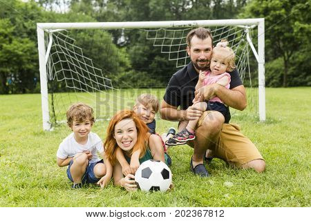A Happy family with football ball on a field