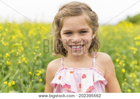 A nice and Happy girl in a field of yellow flowers