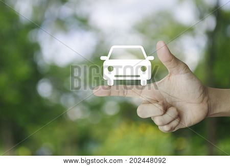 Car flat icon on finger over blur green tree background Business service car concept