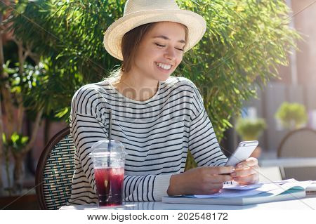 Horizontal Summer Photo Of Good-looking European Girl In Hat And Striped Top Spending Afternoon In O