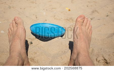 flying saucer lying on the sand between his legs