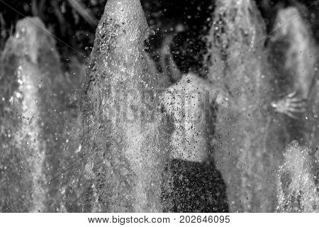 Child Playing At Picadilly Gardens Water Fountains, Manchester- Rear View