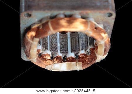 Stator of an old electric motor on a black background.