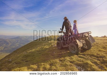 Couple driving off-road with quad bike or ATV.