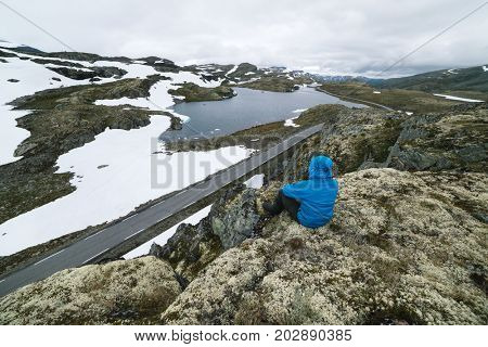 Norway, Lake Flyvotni. Near Sogn og Fjordane County Road. Norwegian Tourist Route Aurlandsfjellet runs from Aurlandsvangen to Laerdalsoyri. Tourist looks at the harsh northern nature