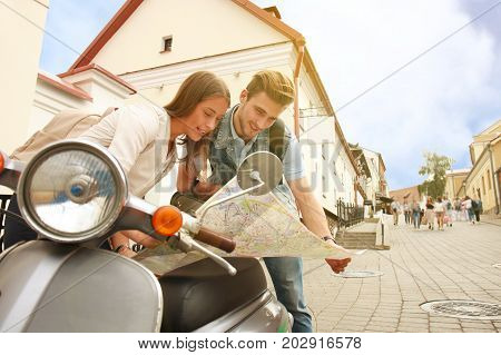 Young Couple with scooter looking at map