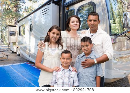 Happy Hispanic Family In Front of Their Beautiful RV At The Campground.