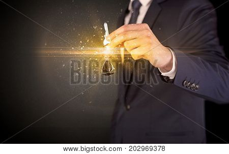Businessman hand  over shiny keys in dark suit with dark background