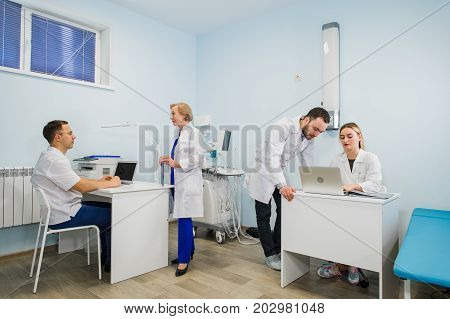 Group Of Doctors Involved In Serious Discussion With Medical Records.
