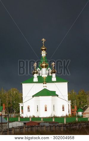 The Image Of A Small Village Church Against A Dark Stormy Sky, Ready At Any Moment To Pour Heavy Rai