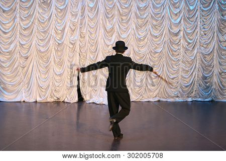 Tap Dance With A Cane In A Black Hat. Dance Step. A Man Is Dancing On Stage