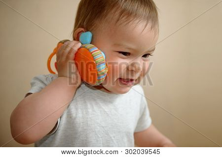 Young Caucasian Baby Girl Talking On A Toy Cell Phone Copy Space, Close Up Portrait