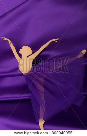 The Plywood Ballerina Figurine Lies On A Purple Fabric