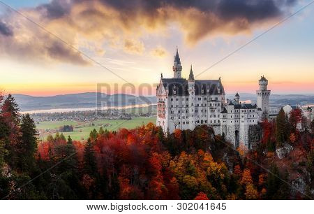 The Famous Neuschwanstein Castle During Sunset, With Colorful Clouds Under Sunlight. Dramatik Pictur