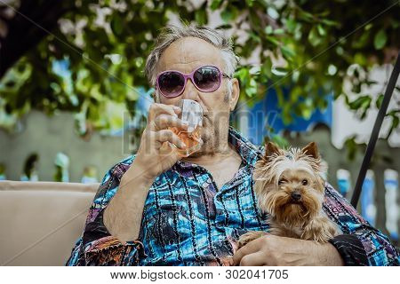 An Old Man With A Dog Drinking Whiskey