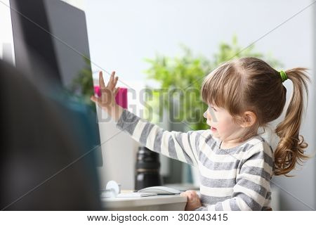Cute Little Girl Sitting At Home At Worktable Working With Computer Portrait