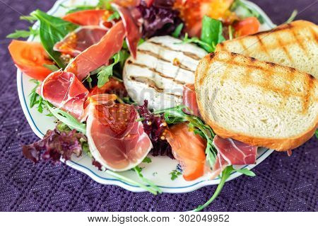 Tasty Mixed Salad Dish With Grilled Camembert Cheese, Prosciutto Ham, Organic Tomato And Fresh Green