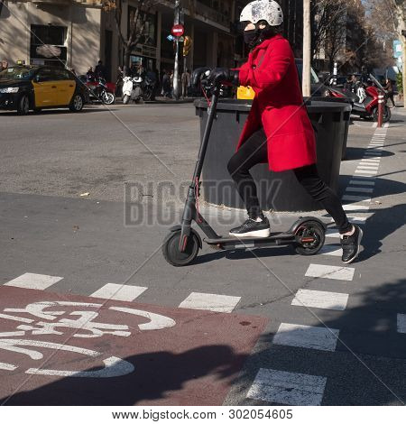 Barcelona, Catalonia / Spain - February-06-2019: Woman Driving An Electric Scooter With Helmet Aroun