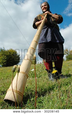 Vrouw speelt de traditionele Roemeense alpenhorn