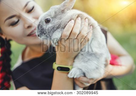Close-up Of Pretty Asian Hugging Bunny On Summer Nature