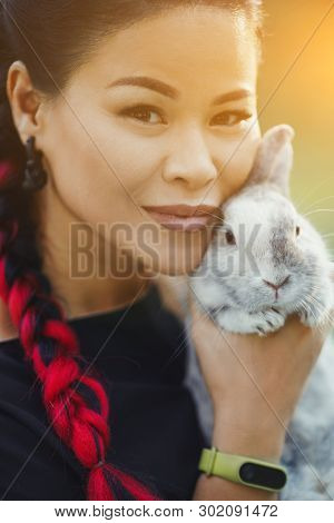 Close-up Portrait Of Pretty Middle-aged Asian With Kanekalon Braiding. Pretty Woman With Little Bonn