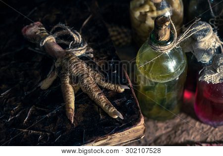 A Witchery Stuff: Multiple Tincture Bottles, Bunches Of Dry Healthy Herbs, Stack Of Ancient Ritual T