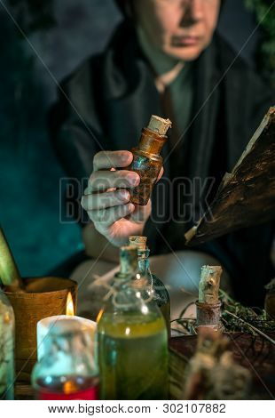 Dark Witch At Work: Black Magic Woman Makes The Witchery By Mixing Herbs, Casting The Spells, Runnin