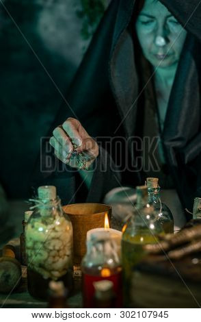 Dark Witch At Work: Black Magic Woman Makes The Witchery By Mixing Herbs, Casting The Spells, Runnin
