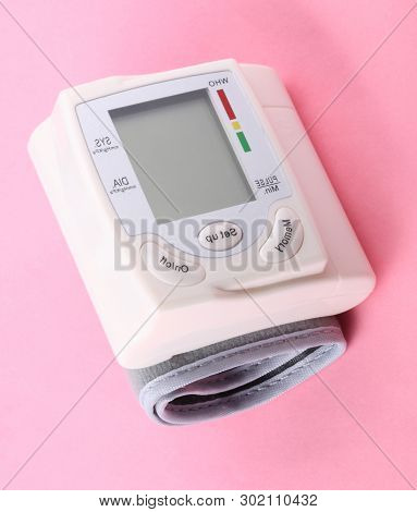 Automatic Wrist Digital Blood Pressure Monitor On Pink Background At Dry Day