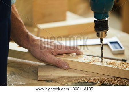Closeup Of Unrecognizable Carpenter Drilling Wood While Working In Joinery, Copy Space