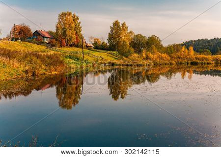 The Lake Near The Village, With Reflection Of Sky, Trees And Houses On A Water Smooth Surface, Russi