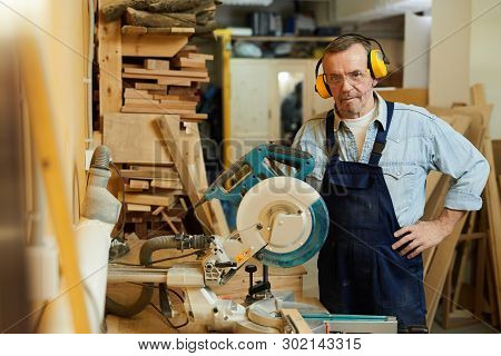 Waist Up Portrait Of Senior Carpenter Posing Standing By Disksawwhile Working In Joinery, Copy Space