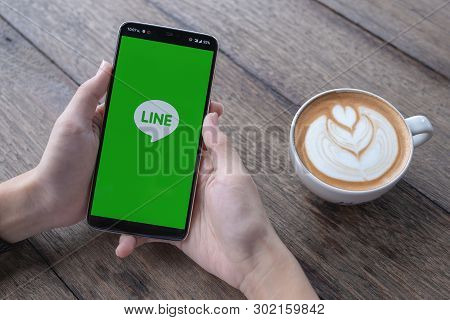 Chiang Mai,thailand - May 11, 2019 : Man Holding Oneplus 6 Alpha With Line App On The Screen On Wood