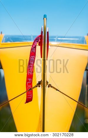 Rear View, Tail Rudder And Red Gust Lock Of Small Prop Airplane.