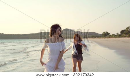 Young Asian Lesbian Couple Running On Beach. Beautiful Women Friends Happy Relax Having Fun On Beach
