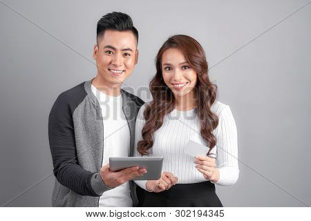 Happy Asian Couple Using Tablet And Credit Card For Online Shopping