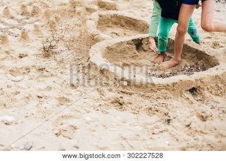 Kids Making Sand Castle On The Beach. Happy Family And Children Playing On The Sand, Making Walls Of