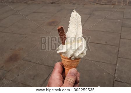 Close Up Shot Of A Man Hand Holding Whipped Ice Cream With A Chocolate Flake Sticking Out The Side, 