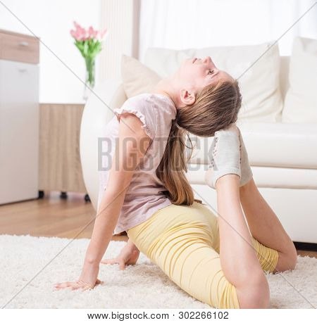 Female sportman doing excellent frog pose on the carpet