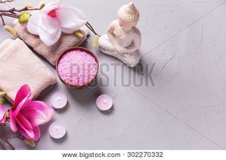 Sea Salt, Burning Candles, Buddha And Pink Magnolia Flowers On Grey Textured Background. Spa Concept