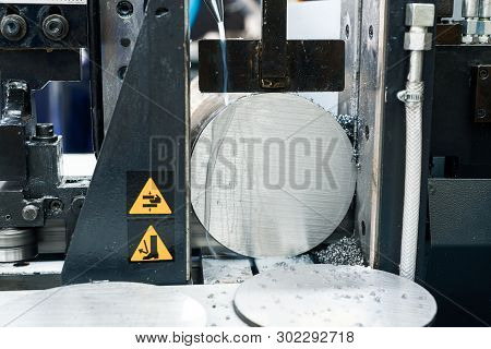 Automatic Bandsaw Sawing Metal Workpiece. From The Cooling Pipes Supplied Lubricity Emulsion.