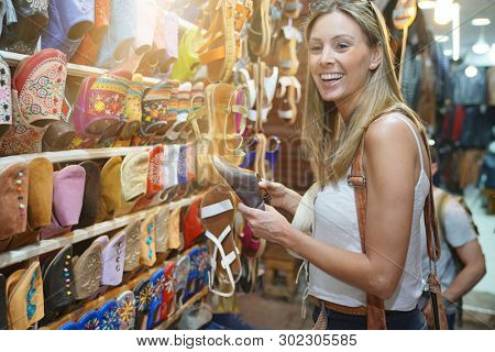 Tourist girl shopping in Moroccan souk of Marrakech