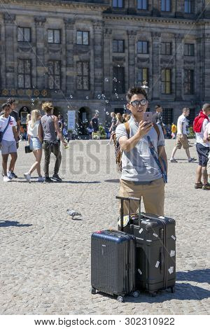 Amsterdam, Netherlands - July 02, 2018: Tourist From China Makes Selfy In The Central Dam Square In