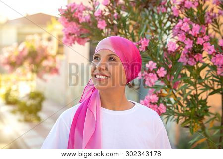 Woman with pink scarf on the head. Cancer awareness