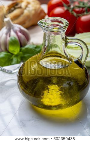 Virgin Natural Olive Oil Is Glass Bottle, Served With Traditional Mediterranean Food
