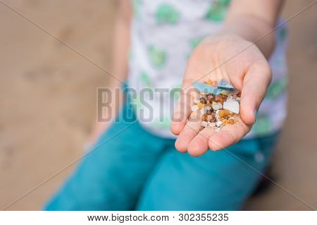 Little Girl Holding Small Tiny Harmful Plastic Beads Collected On The Beach In Zante, Zakynthos, Gre
