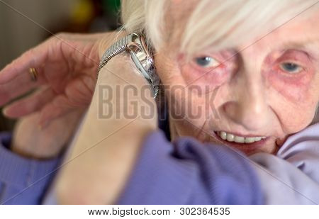 Elderly Lady With Macular Degeneration Listens To Her Speaking Wrist Watch,england,u.k.
